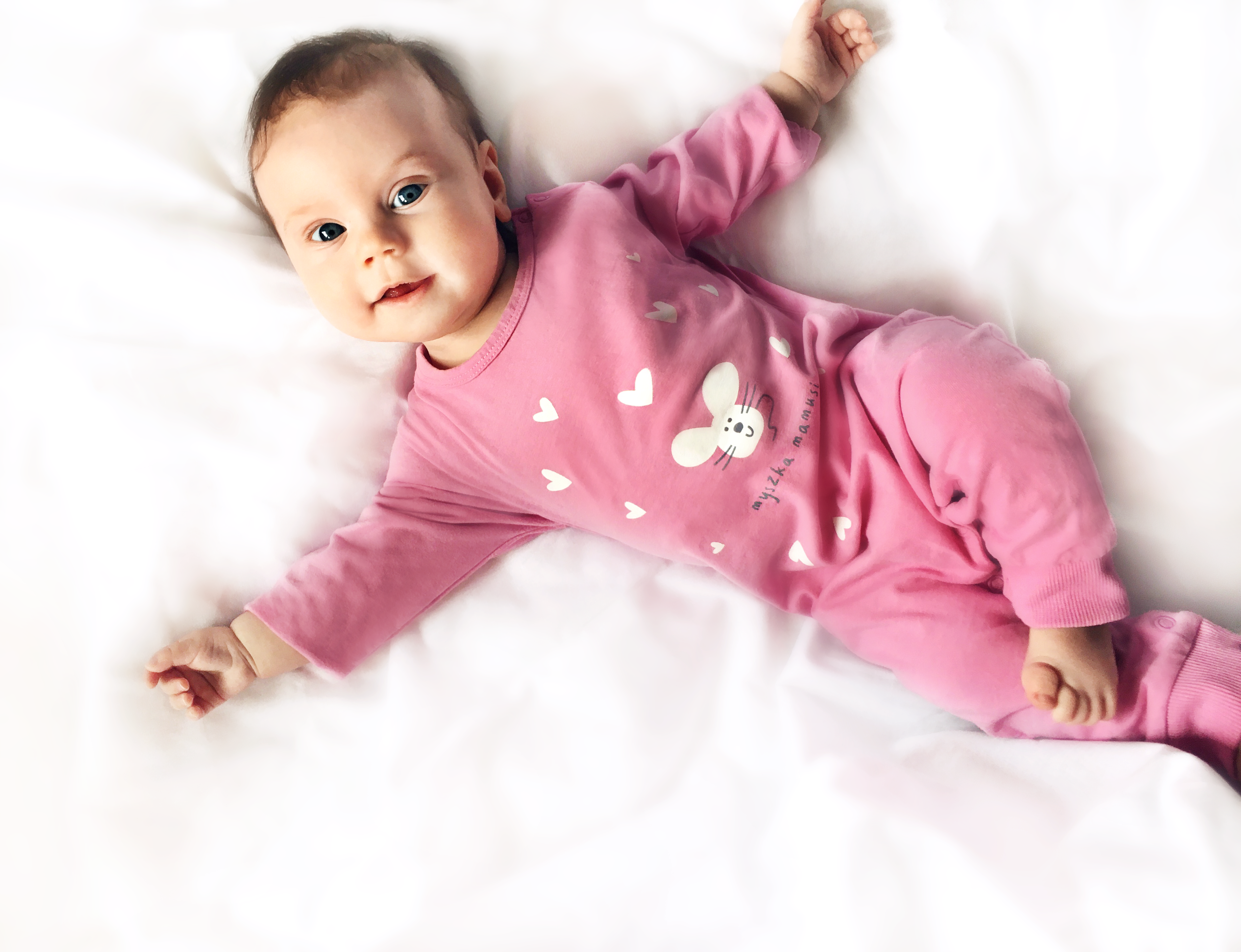 Niemowlę w różowym body.|Śpiące niemowlę ze smoczkiem w buzi, w body z lewkiem.|Granatowy rampers dla niemowlaka.|Różowe legginsy dla niemowlaka z nadrukiem piesków na kolanach.|Niebieski kaftanik dla niemowlaka z oferty Endo, z pieskiem.|Kaftanik dla ...