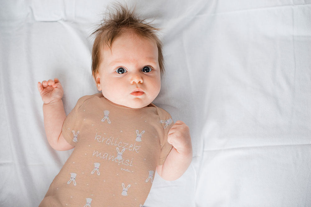 dziewczynka ubrana w lato Śpiące niemowlę ubrane w granatową koszulkę i spodnie, ze smoczkiem w buzi.|Śpiące niemowlę przykryte kocykiem. Stópki niemowlęcia w niebieskim pajacyku z nadrukiem łapek psa.|Śpiące niemowlę ze smoczkiem w buzi.|Metka z ubran...