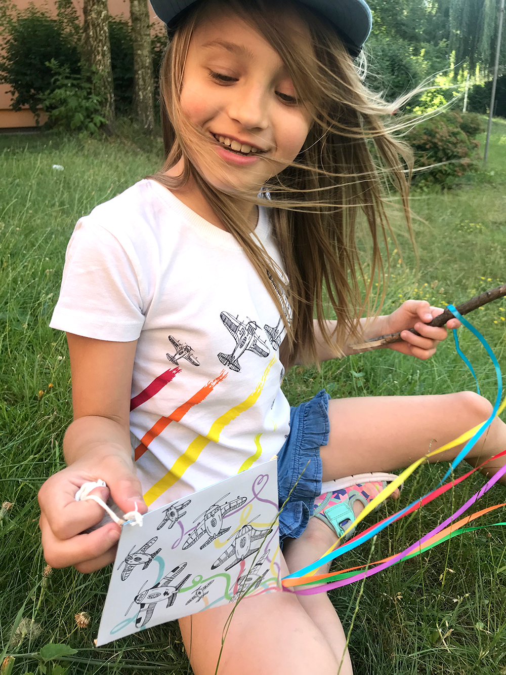 Dziewczynka bawiąca się latawcem z papieru