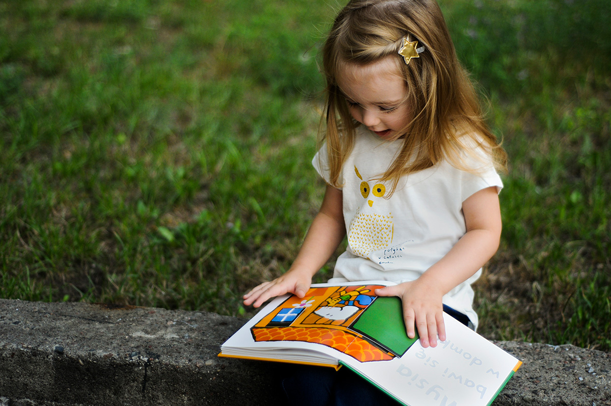 mała dziewczynka czytająca książkę o przedszkolu