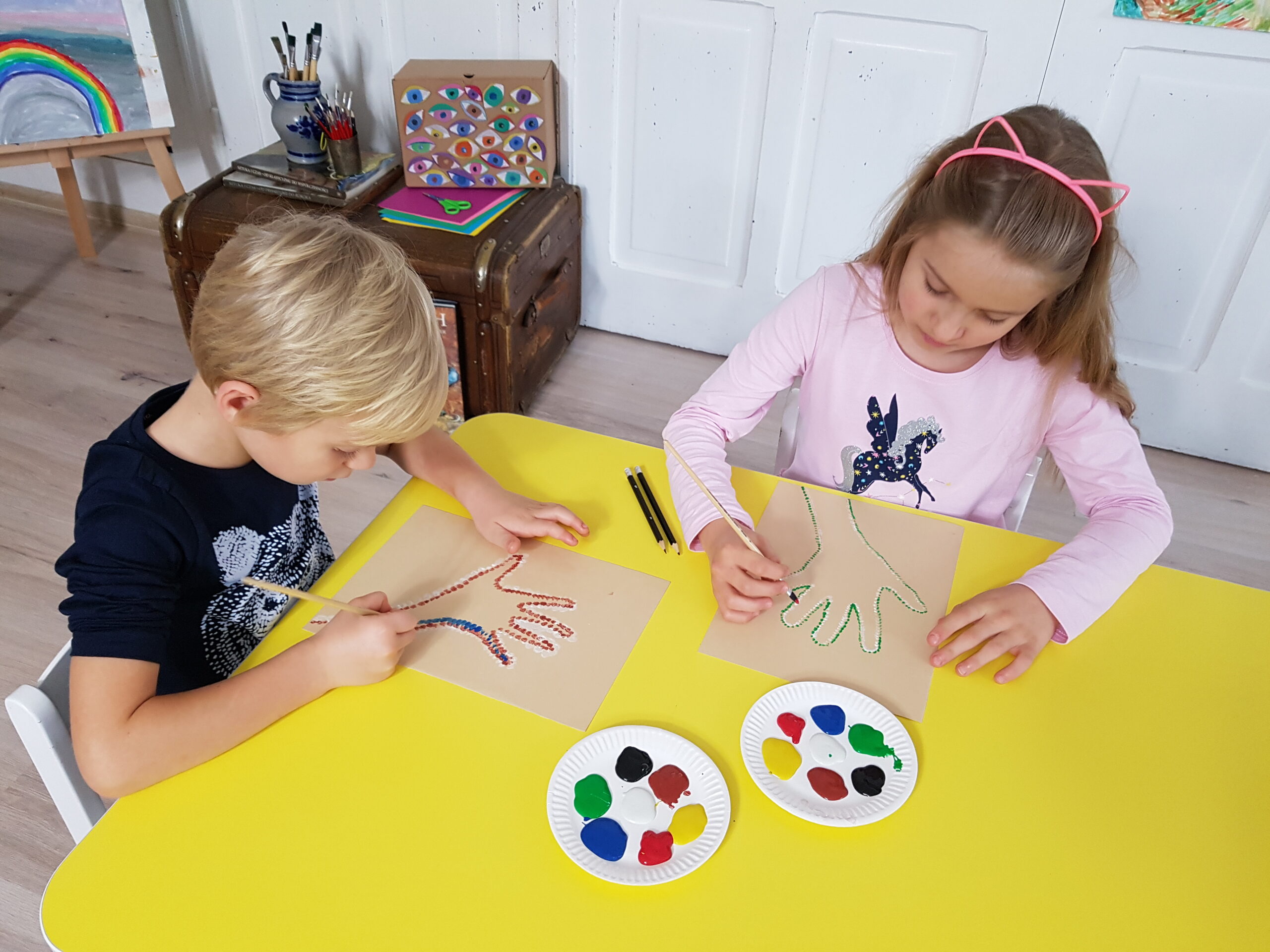 Dzieci tworzą prace plastyczne malując kropkami.