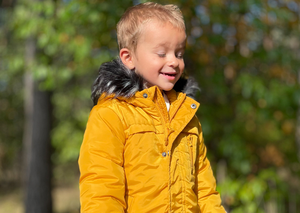 Jak wzmocnić odporność dziecka - Uśmiechnięty chłopiec w zimowej kurtce