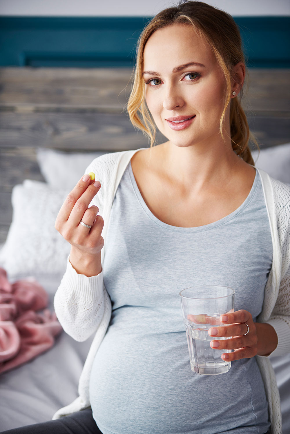 Dieta w ciąży - kobieta przyjmuje witaminy