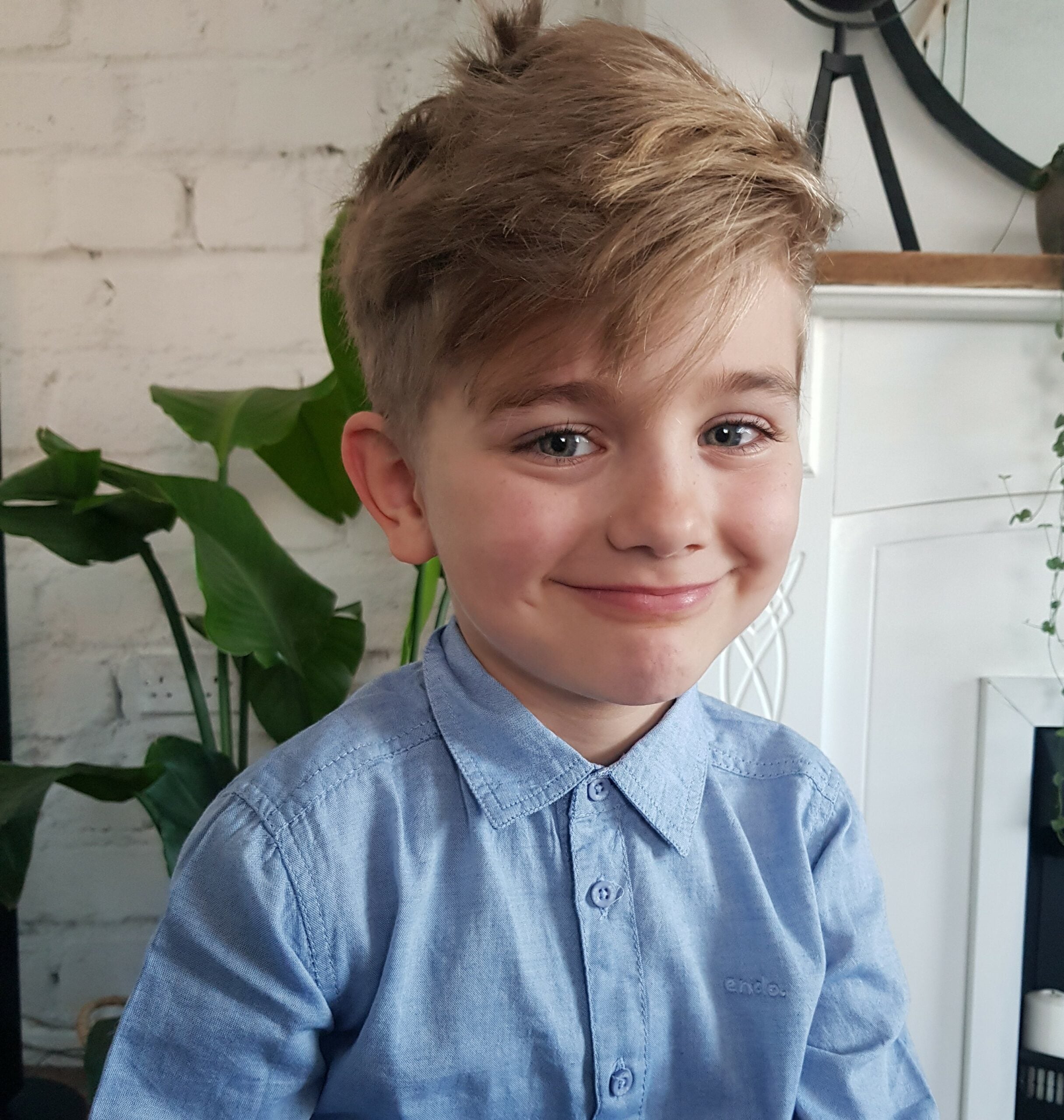 Mały chłopiec w niebieskiej koszuli Endo gotowy na pierwszy dzień szkoły.|Ruda dziewczynka ubranka w niebieską koszulę i niebieską spódniczkę. Zdjęcie białej koszuli dla dziewczynki z motylkowym rękawkiem.|Błękitna spódniczka Endo z haftem. Dziewczynka...